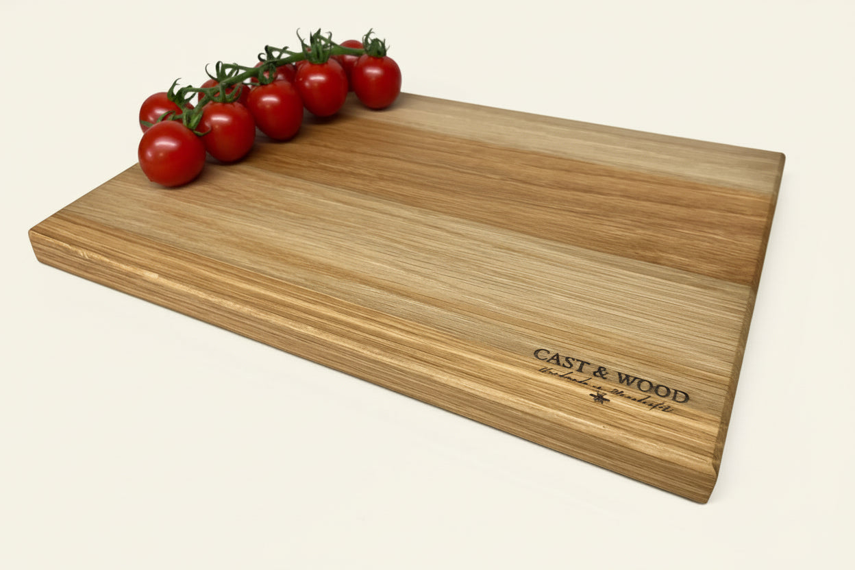 Wooden chopping board with a smooth surface and tomatoes, featuring an engraving on one side.