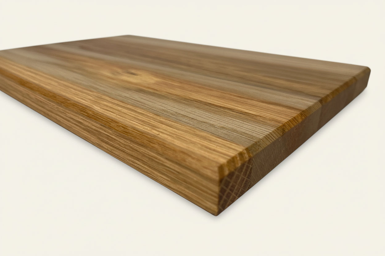 Large rectangular oak chopping board with smooth surface and visible grain patterns, featuring rounded edges.