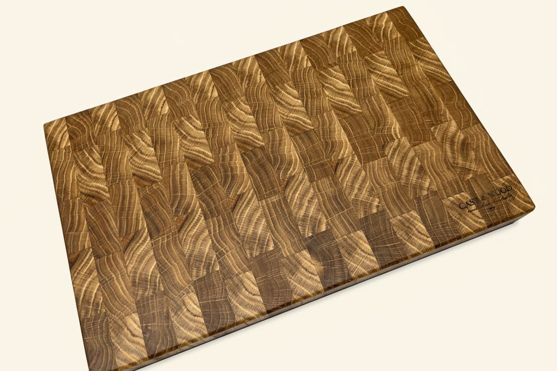 Large rectangular chopping board with a smooth end grain pattern, showcasing various wood tones and a flat surface.