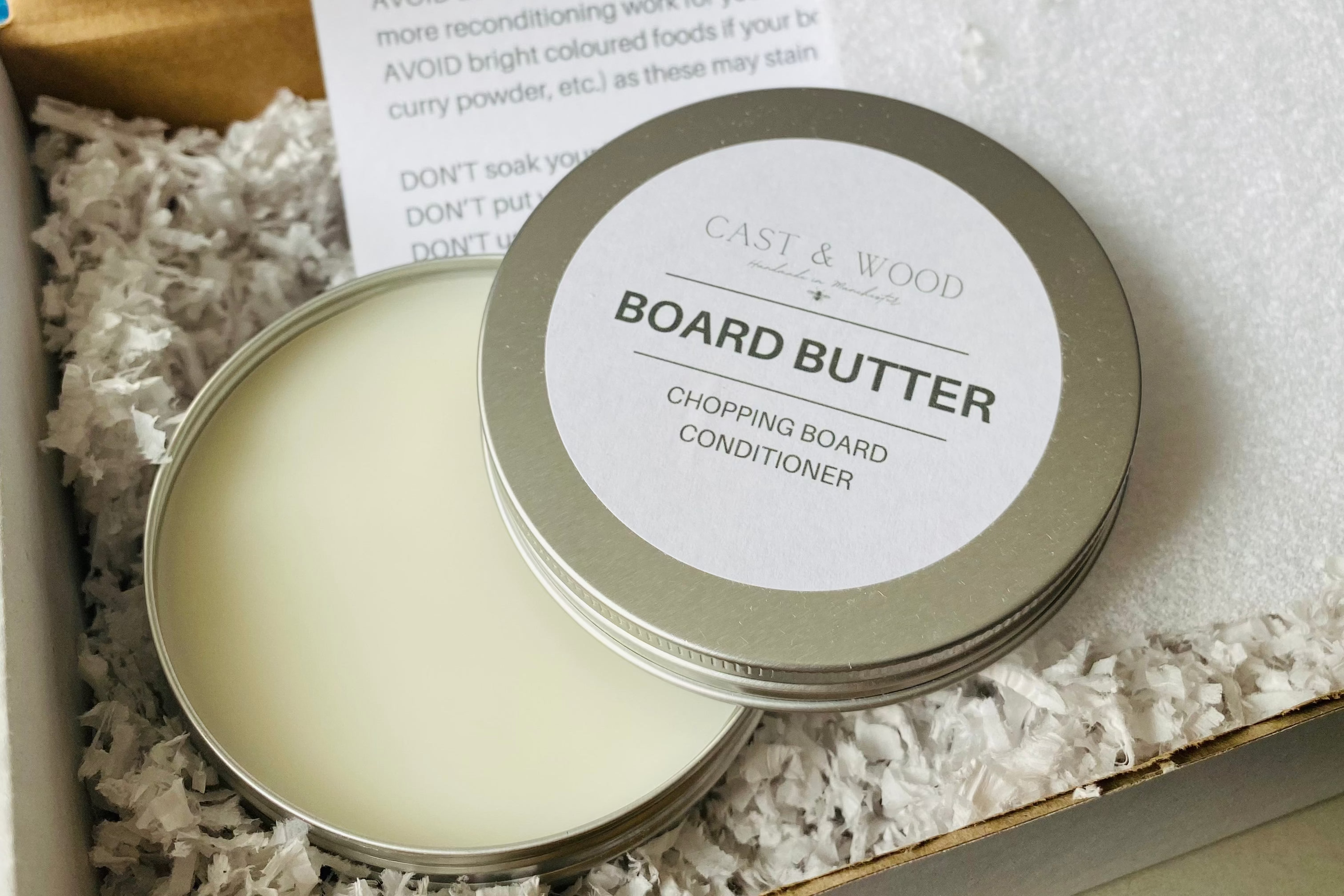 Tin of Board Butter for chopping board conditioning, presented in a box with shredded paper filling.
