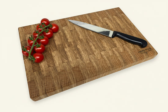 Large Heaton end grain chopping board with a smooth surface, knife, and cherry tomatoes displayed on it.