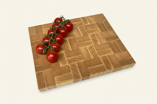 Square Mayfield End Grain Chopping Board with a blocked design and cherry tomatoes on one corner.