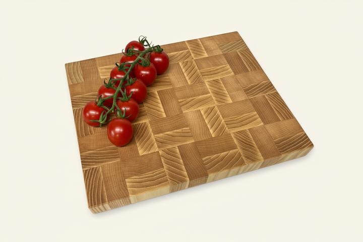 Square Mayfield End Grain Chopping Board with a blocked design and cherry tomatoes on one corner.