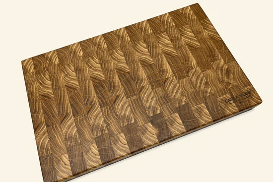 Large rectangular chopping board with a smooth end grain pattern, showcasing various wood tones and a flat surface.