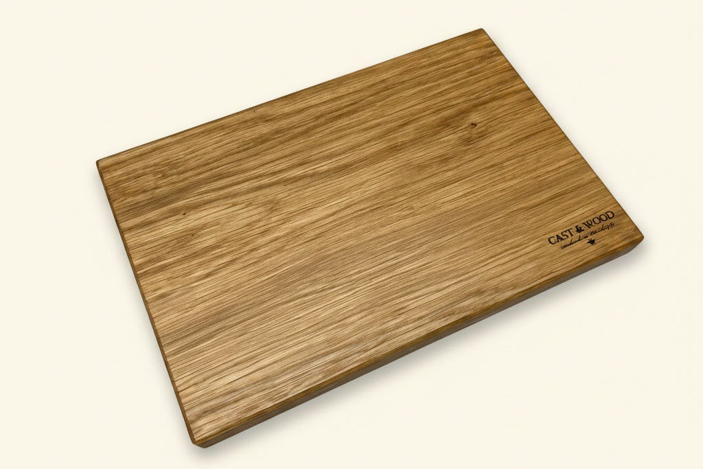 Wooden chopping board with a smooth surface and natural grain, featuring an engraving in one corner.