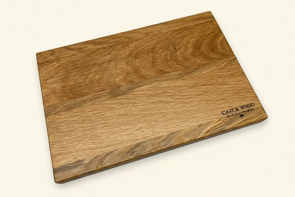 Rectangular chopping board with a smooth surface, rounded edges, and natural wood finish, featuring an engraving in the corner.