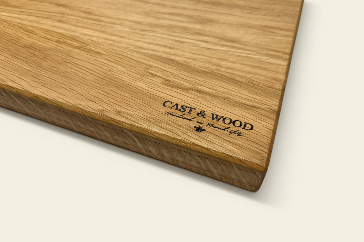 Wooden chopping board with a smooth surface and visible grain, featuring 'CAST & WOOD' printed on it.