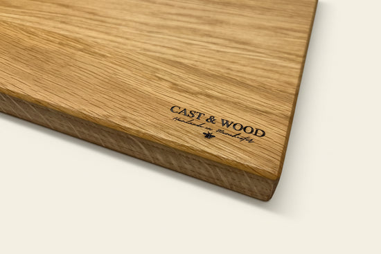 Wooden chopping board with a smooth surface and visible grain, featuring 'CAST & WOOD' printed on it.