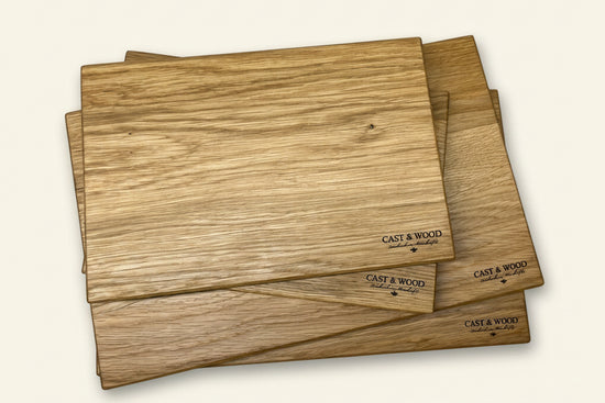 Set of four rectangular chopping boards with smooth surfaces and natural wood grain patterns.