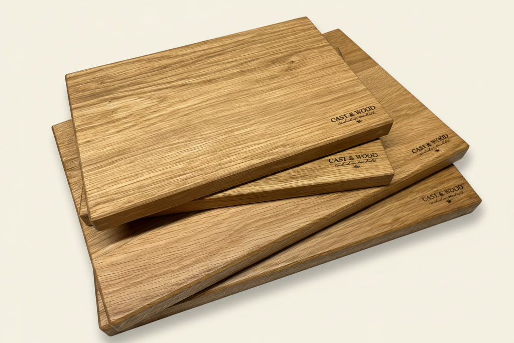 Set of four natural wood chopping boards stacked, showcasing their rectangular shape and artisanal finish.